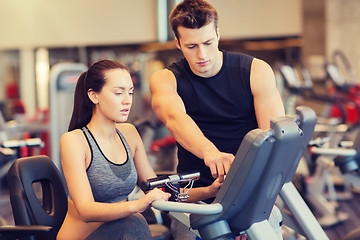 Image showing woman with trainer on exercise bike in gym