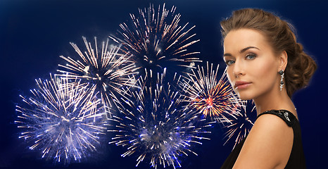 Image showing beautiful woman wearing earrings over firework