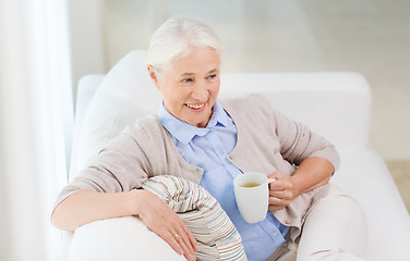 Image showing happy senior woman with cup of tea at home