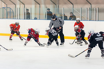 Image showing Puck playing between players of ice-hockey teams