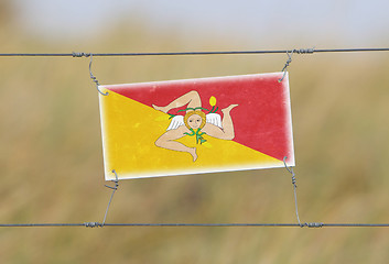 Image showing Border fence - Old plastic sign with a flag