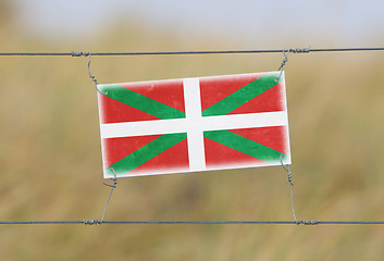 Image showing Border fence - Old plastic sign with a flag