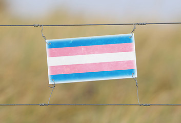 Image showing Border fence - Old plastic sign with a flag