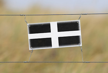 Image showing Border fence - Old plastic sign with a flag