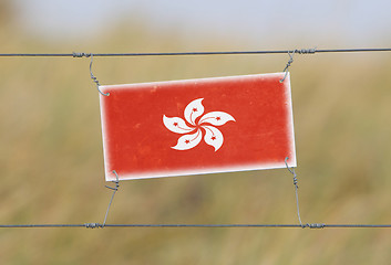 Image showing Border fence - Old plastic sign with a flag