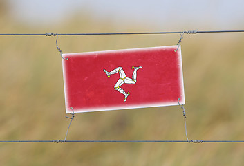 Image showing Border fence - Old plastic sign with a flag