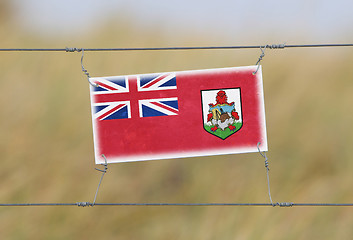 Image showing Border fence - Old plastic sign with a flag