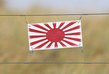 Image showing Border fence - Old plastic sign with a flag