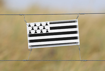 Image showing Border fence - Old plastic sign with a flag