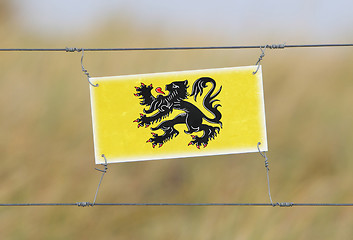 Image showing Border fence - Old plastic sign with a flag