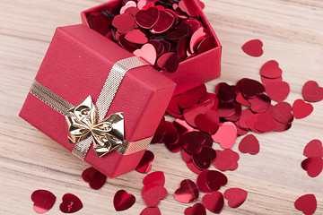 Image showing Red hearts confetti on wooden background