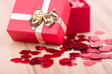 Image showing Red hearts confetti on wooden background