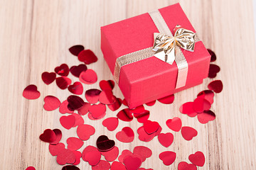 Image showing Red hearts confetti on wooden background