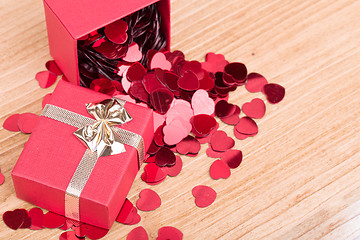 Image showing Red hearts confetti on wooden background