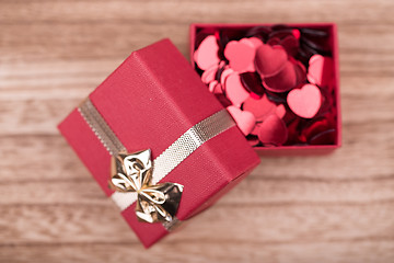 Image showing Red hearts confetti on wooden background