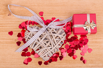 Image showing Red hearts confetti on wooden background