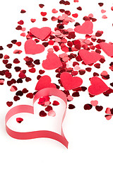 Image showing Red hearts confetti and fabric heart on white background