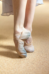 Image showing The close-up feet of young ballerina in  old pointe shoes 