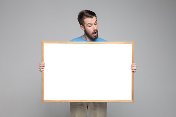 Image showing The surprised man showing empty white billboard or banner 