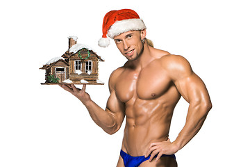 Image showing Attractive young muscle man smiling in Santa Claus\'s red hat