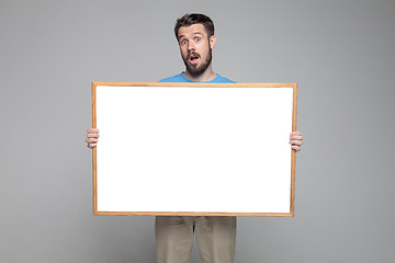 Image showing The surprised man showing empty white billboard or banner 