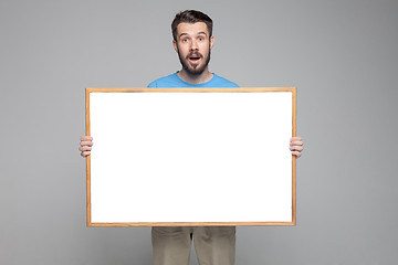 Image showing The surprised man showing empty white billboard or banner 