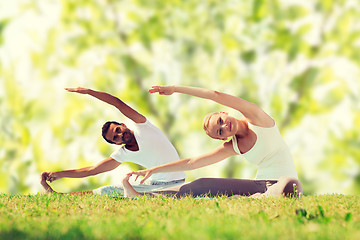 Image showing happy couple stretching and doing yoga exercises