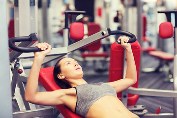 Image showing young woman exercising on gym machine