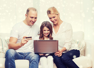 Image showing happy family with laptop computer and credit card