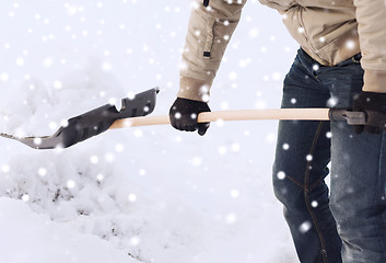 Image showing closeup of man digging snow with shovel