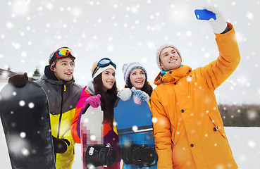 Image showing happy friends with snowboards and smartphone