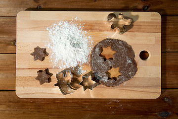 Image showing close up of ginger dough, molds and flour on board