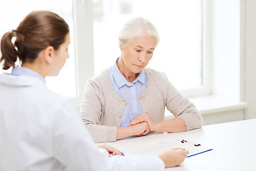 Image showing doctor with clipboard and senior woman at hospital