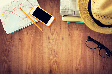 Image showing close up of summer clothes and travel map on table