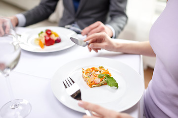 Image showing close up of couple eating appetizers at restaurant