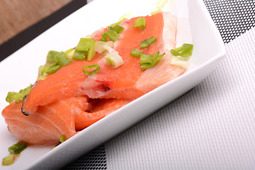 Image showing Salted salmon fillet with parsley leaf on the white bowl