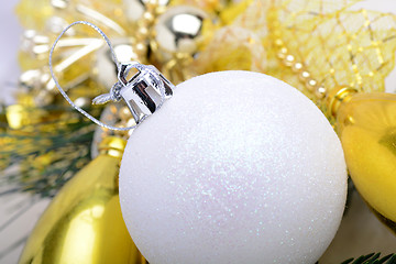 Image showing festive golden christmas decoration, candles, white balls, green fir tree branch, close up