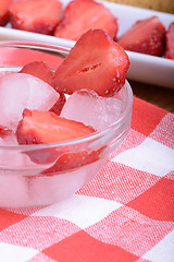 Image showing A slice of red strawberry on glass plate in party theme background