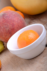 Image showing Mandarin Apples Bananas Peach on wooden plate