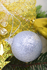 Image showing festive golden christmas decoration, candles, white balls, green fir tree branch, close up