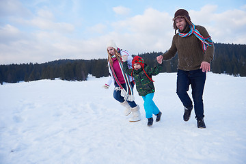 Image showing happy family playing together in snow at winter