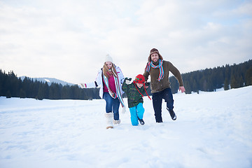 Image showing happy family playing together in snow at winter