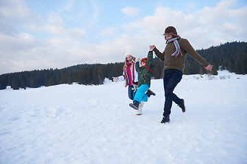 Image showing happy family playing together in snow at winter