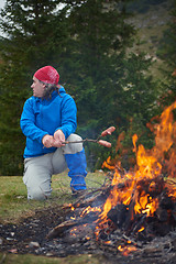 Image showing hiking man prepare tasty sausages on campfire