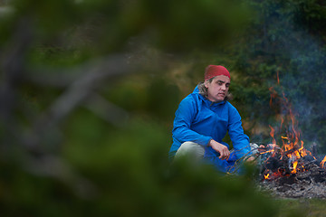 Image showing hiking man prepare tasty sausages on campfire