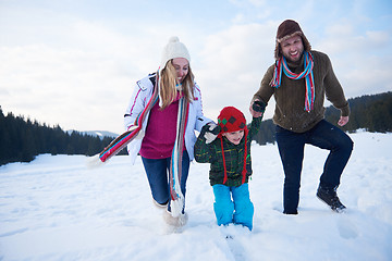 Image showing happy family playing together in snow at winter