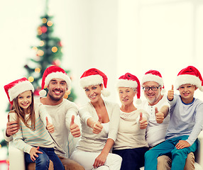 Image showing happy family in santa hats showing thumbs up