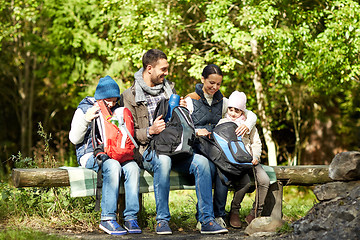 Image showing happy family with backpacks and thermos at camp