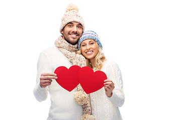 Image showing smiling couple in winter clothes with red hearts