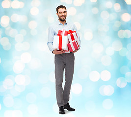 Image showing happy young man holding gift boxes